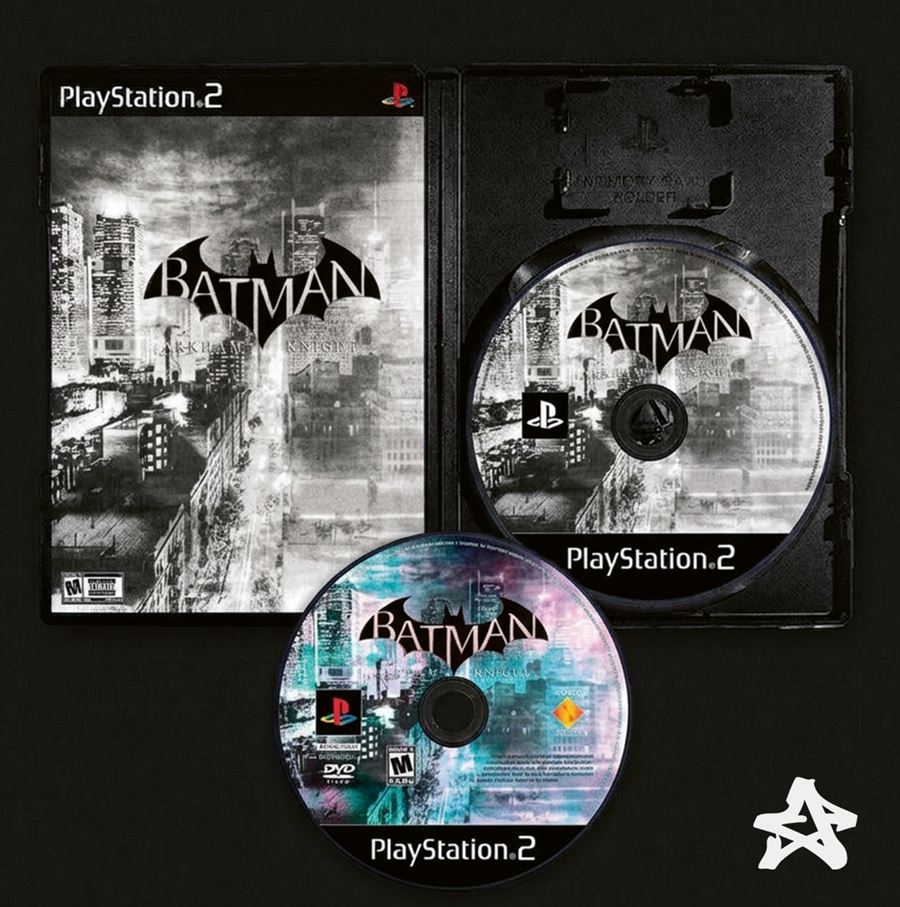 Un boîtier de PlayStation 2 ouvert : la jaquette Batman en noir et blanc glissée à gauche, deux disques du jeu posés à droite.